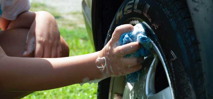 Kid washing a car tire