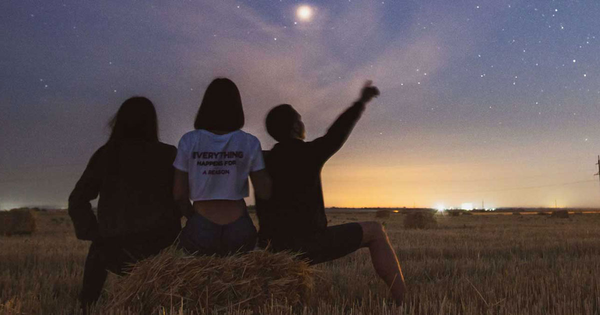Three people looking at stars