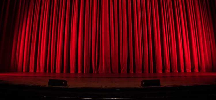 a stage with a closed red curtain