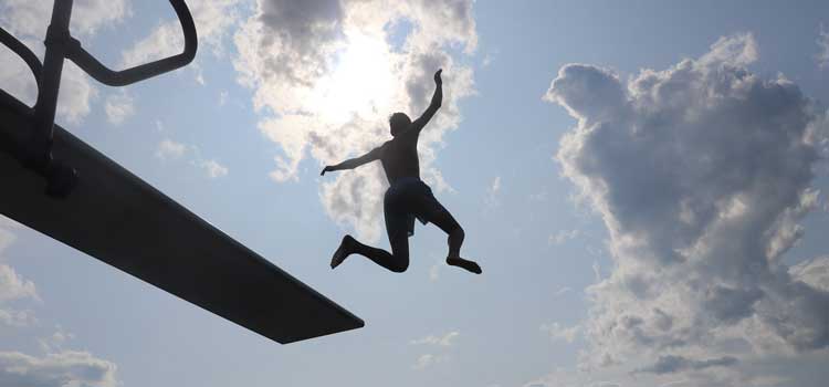 a kid jumping off a diving board