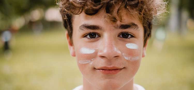 close up photo of a boy with face paint under his eyes