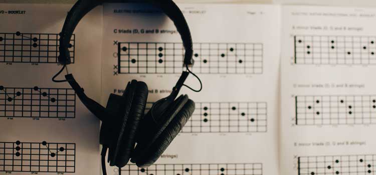 headphones and guitar chord book
