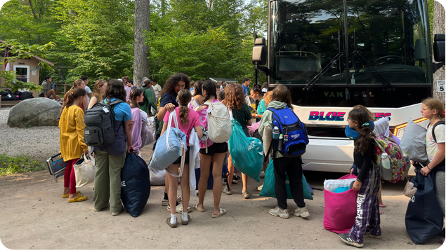 Kids waiting to board a bus to camp