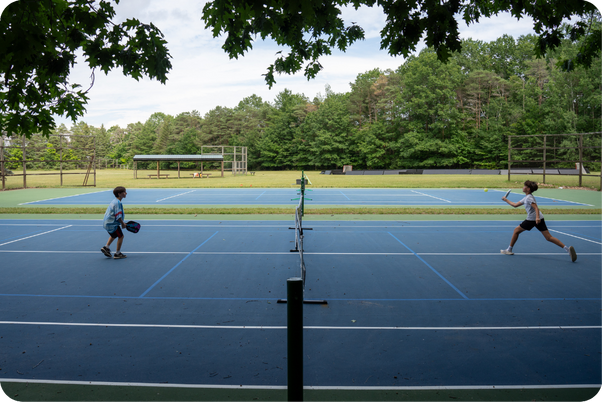 Kids playing tennis at summer camp