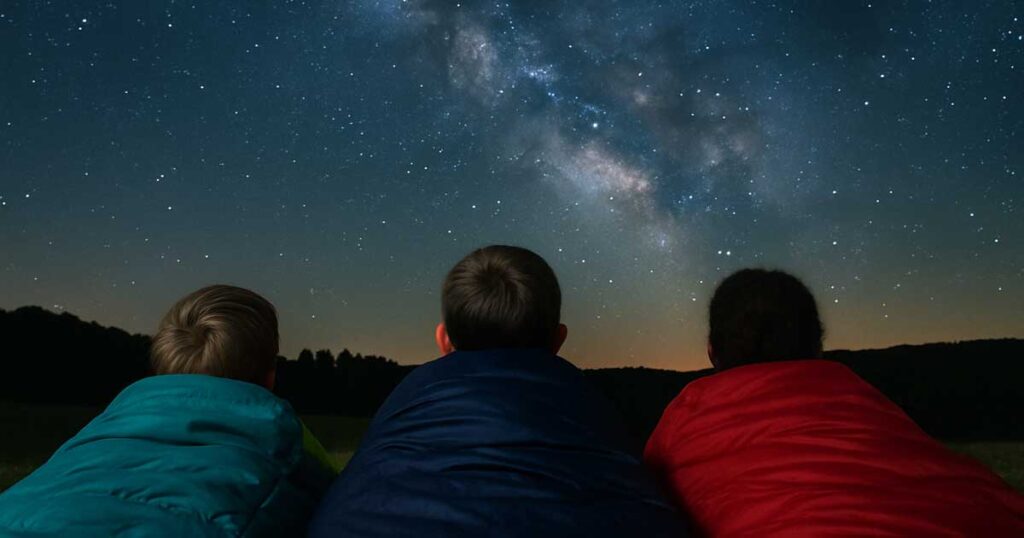 kids stargazing for unique nighttime camp activities